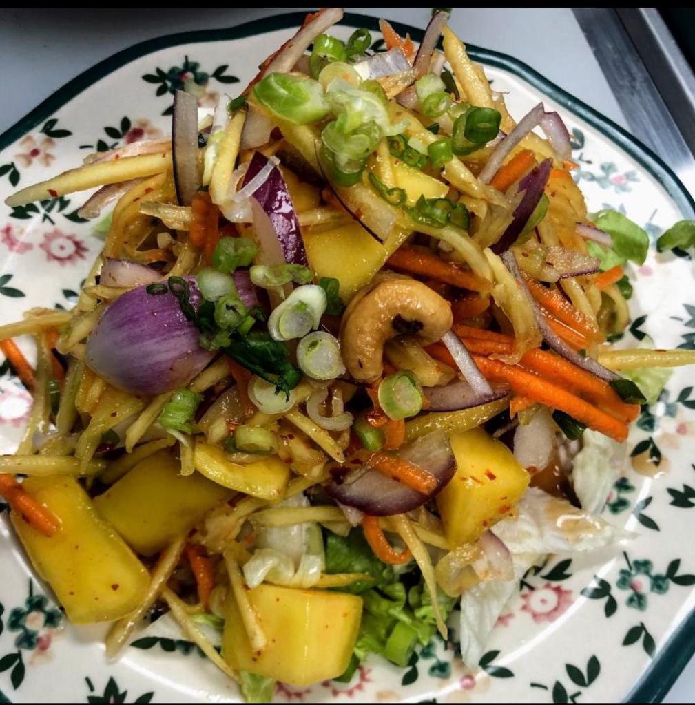 Mango Salad · Fresh Mango, chili, red onion, scallions, cashew nuts, carrots and lettuce tossed in a refreshing lime dressing.