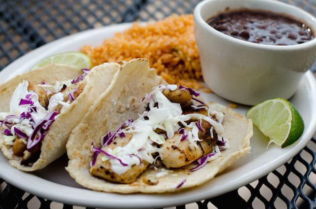 Fish Taco Dinner · Seasoned fork-tender pieces of tilapia filet (whitefish) grilled to perfection and served in our own freshly-made corn tortillas with cabbage slaw and a cilantro lime-cream sauce. Served with black beans and rice.
