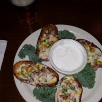 Potato Skins · Cored Russet potato's lightly fried with bacon, signature cheese blend and green onions. Ser...