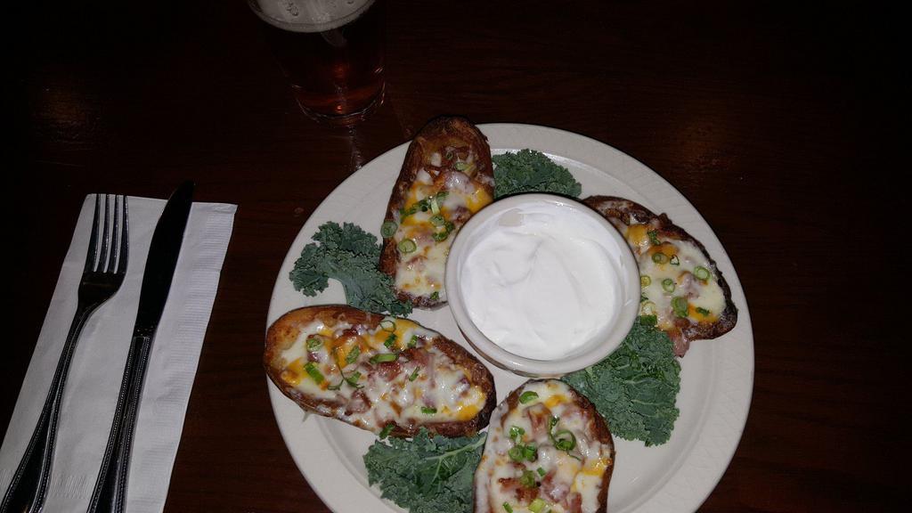 Potato Skins · Cored Russet potato's lightly fried with bacon, signature cheese blend and green onions. Served with Sour Cream.