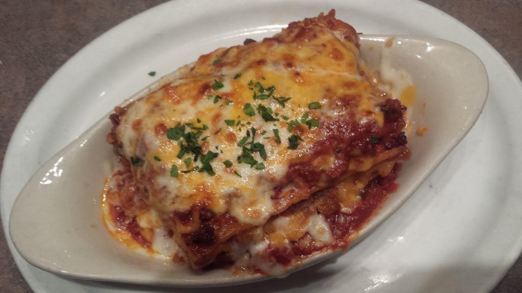 Signature Meat Lasagna · Blend Italian sausage, Italian beef, and salami layered between thick pasta with a blend of cheeses and meat sauce. Served with baked focaccia bread.
