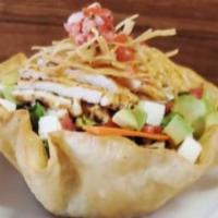 Mexican Chicken Taco Salad · Taco shell filled with lettuce, black beans, avocado, panela cheese and pico de gallo, and c...