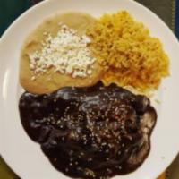 Chicken Mole · Chicken in red mole sauce and served with Mexican rice, peruano or black beans, and handmade...