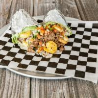 Surf Turf Burrito 51500 · Chopped cilantro, lime rice, black beans, shrimp, carne asada, pico de gallo, lettuce, bad a...