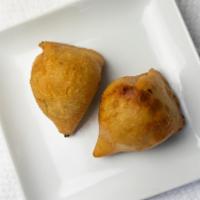 Vegetable Samosa · Minced Potato and Peas wrapped in pastry dough and fried.