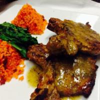 Chuletas Mexicana · Grilled pork chops with tomatillo sauce all over, Mexican rice and spinach as accompaniment.