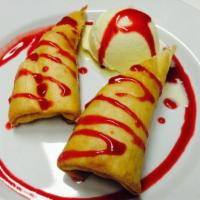 Guadalupe's Fried Cheesecake · A deep-fried cheesecake roll with vanilla ice on the side, garnished with strawberry syrup.
