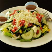 Greek Salad · Greens, tomatoes, cucumbers, onions, black olives, banana peppers, feta cheese and served wi...