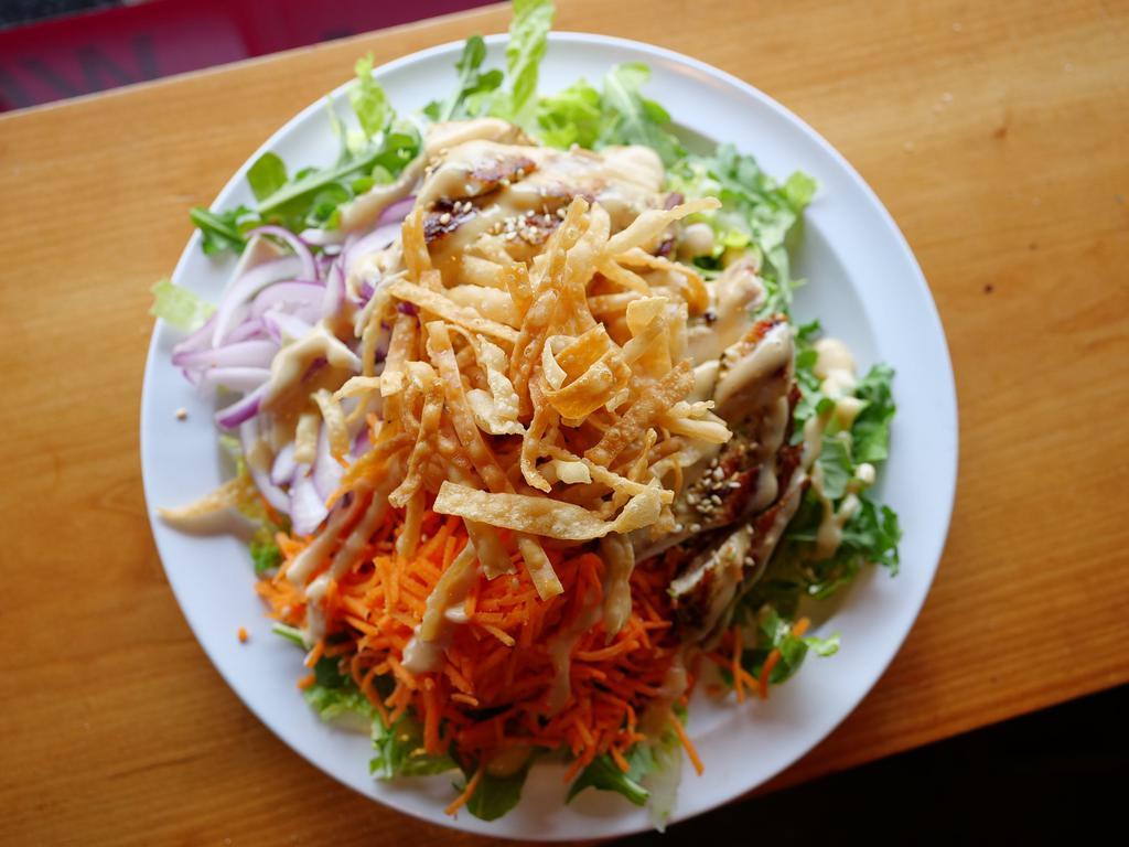 Asian Sesame Chicken Salad · Marinated grilled chicken, sesame seeds, mixed greens, shredded carrots, red onions, crispy wontons and honey ginger dressing. Served with pita bread.