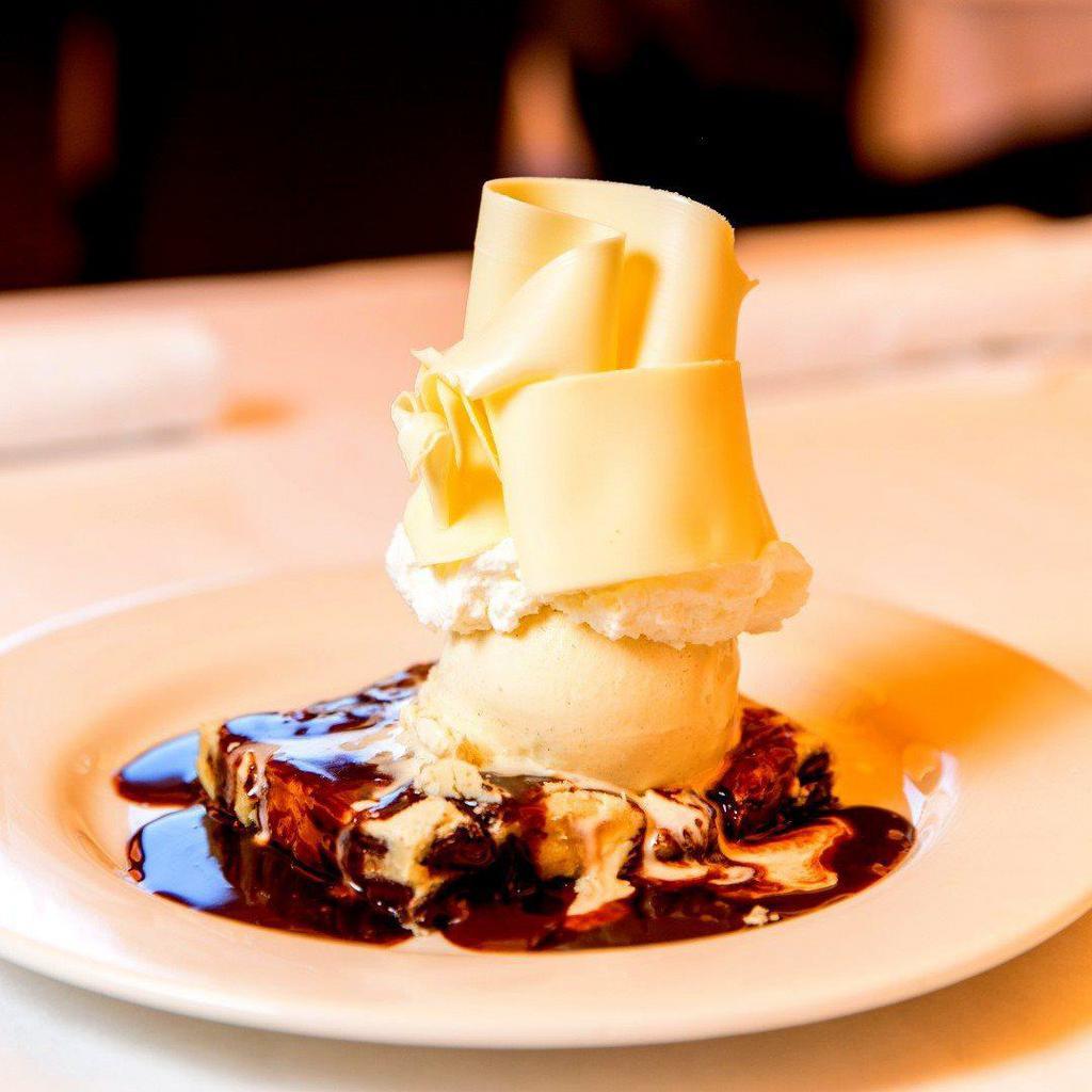 White Chocolate Brownie · A warm blonde brownie freshly baked with Callebaut chocolate. Topped with French vanilla ice cream, warm chocolate sauce and whipped cream.
