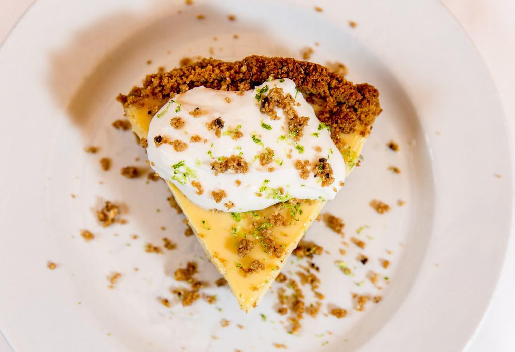 Key Lime Pie · A traditional creamy and tart key lime pie with a graham cracker crust topped with coconut whipped cream and freshly zested lime.
