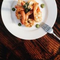 Gamberoni Grigliati · Grilled jumbo shrimp with braised vegetables and pesto sauce.