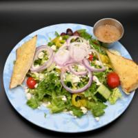 Greek Salad · Tomatoes and cucumbers served on a bed of lettuce topped with Feta cheese, banana peppers, o...