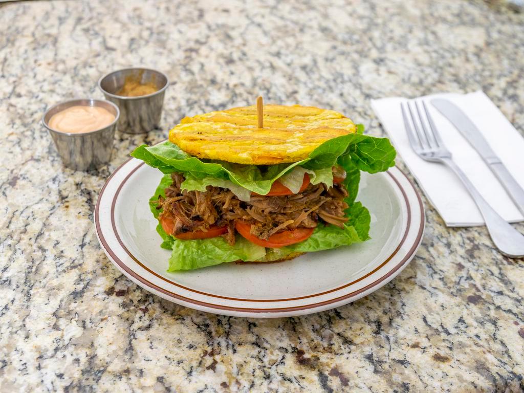 Patacon · Fried plantain sandwich. Fried green plantain, chicken, beef or pork, lettuce, tomato, garlic mojito, ketchup and mayo sauce.
