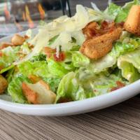 Classic Caesar Salad · Romaine hearts, crispy smoked bacon, shaved Parmesan, and garlic croutons.