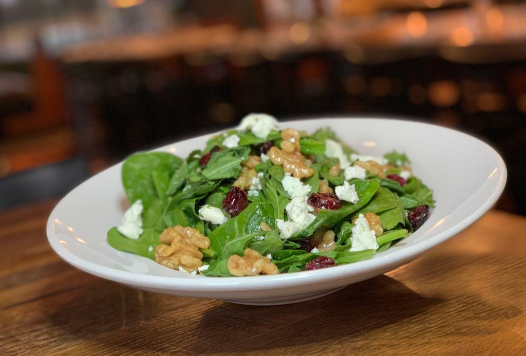 Goat in the Garden Salad · Baby arugula, spinach leaves, dried cranberries, candied walnuts, goat cheese, red wine, and vinegar dressing.