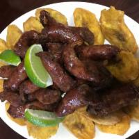 Longaniza Frita con Tostones · Dominican sausage with fried green plantains.
