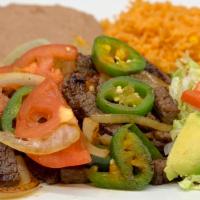 Bistec a la Mexicana Dinner · Steak, rice, beans, lettuce, tomato, and a side of tortillas.