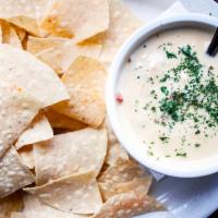 Chips and Queso · Onions, garlic, tomatoes, green chiles and jalapeños in our savory melted cheese dip. Served...