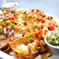 Nachos · Tortilla chips topped with seasoned ground beef, chicken or both, plus melted cheddar and ja...