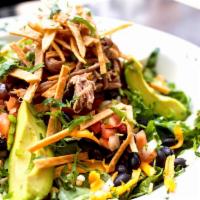 Cilantro Ranch Carnitas Salad · Leafy greens topped with pork carnitas, black beans, pico de gallo, avocado, cilantro, shred...