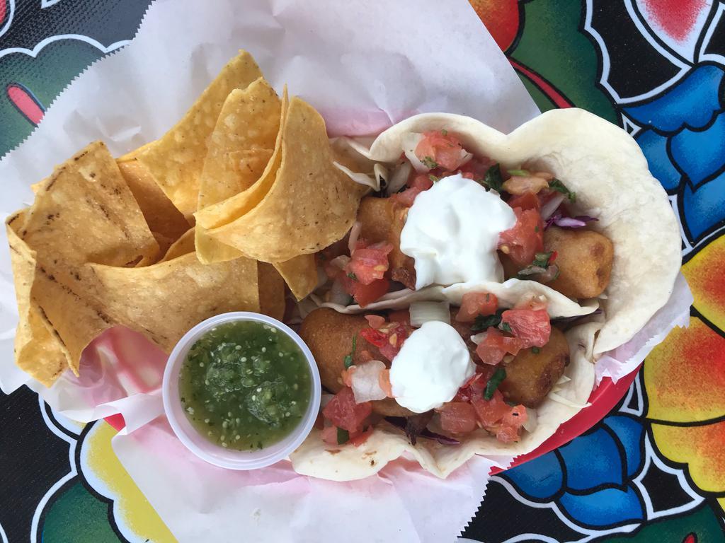 Beer Battered Cod Tacos · Two beer battered pacific cod tacos with shredded cabbage, pico, crema agria & a squeeze 'o lime. Served with a ramekin of salsa and a handful of chips.  Add minted rice and black beans to make it a meal!