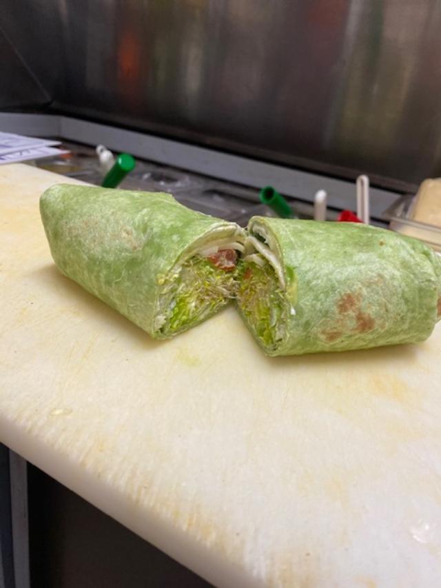 Evergreen Buritto · Scrambled eggs, turkey, spinach, bell pepper, onions and melted provolone cheese wrapped in a spinach tortilla