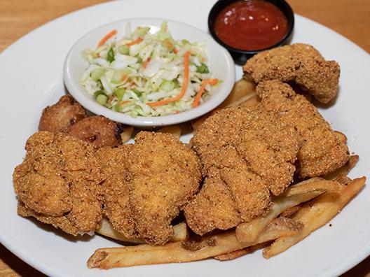 Southern Fried Catfish · U.S. farmed catfish fillets battered in seasoned cornmeal. Served with housemade tartar sauce. served with crispy fries, homemade apple cider slaw, and jalapeño hush puppies.