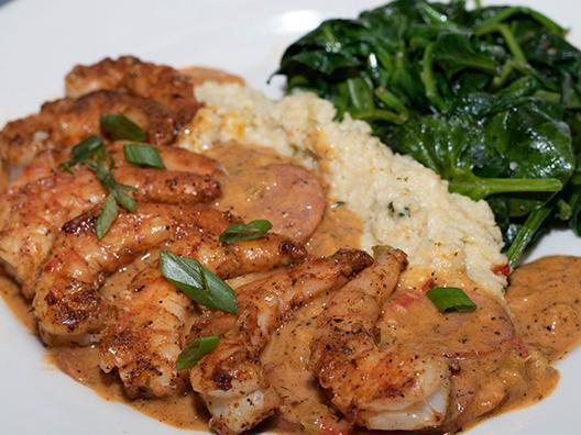 Shrimp and Grits · Large blackened shrimp on a bed of jalapeño cheese grits with smoked Andouille sausage gravy. Served with sautéed spinach.
