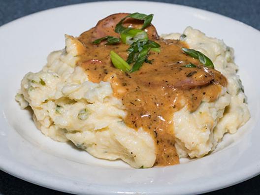 Jalapeno Cheese Grits · Creamy jalapeno cheese grits topped with andouille sausage gravy. (Contains Pork)