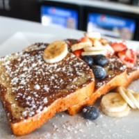 Gluten Free French Toast · Garnished with fresh berries, bananas, cinnamon and powdered sugar. served with sugar free s...