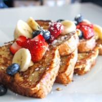 Multigrain French Toast · Garnished with fresh berries, bananas, cinnamon and powdered sugar. served with sugar free s...