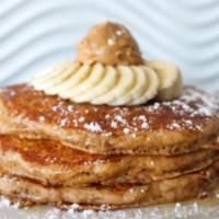 PB Whole Wheat Pancakes · Whole wheat oatmeal pancakes topped with peanut butter, fresh bananas and powdered sugar. dr...