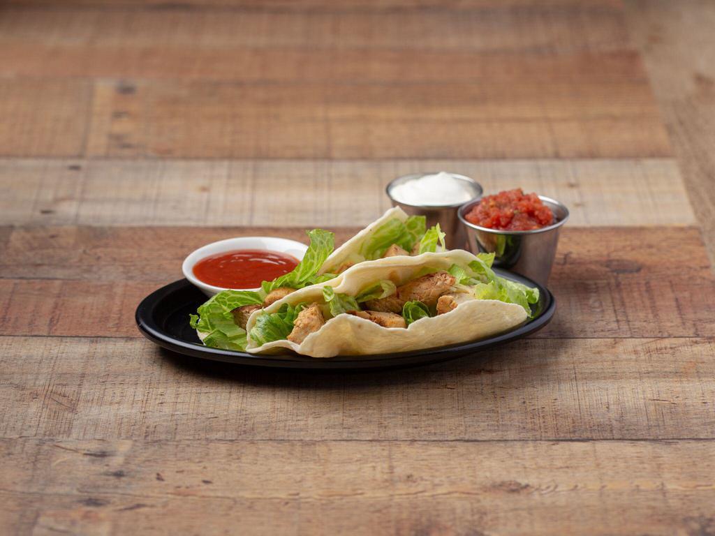 Grilled Chicken Tacos · Marinated with chipotle peppers and lime. Two tacos topped with salsa, sour cream, chipotle sauce, cheddar jack cheese and lettuce.
