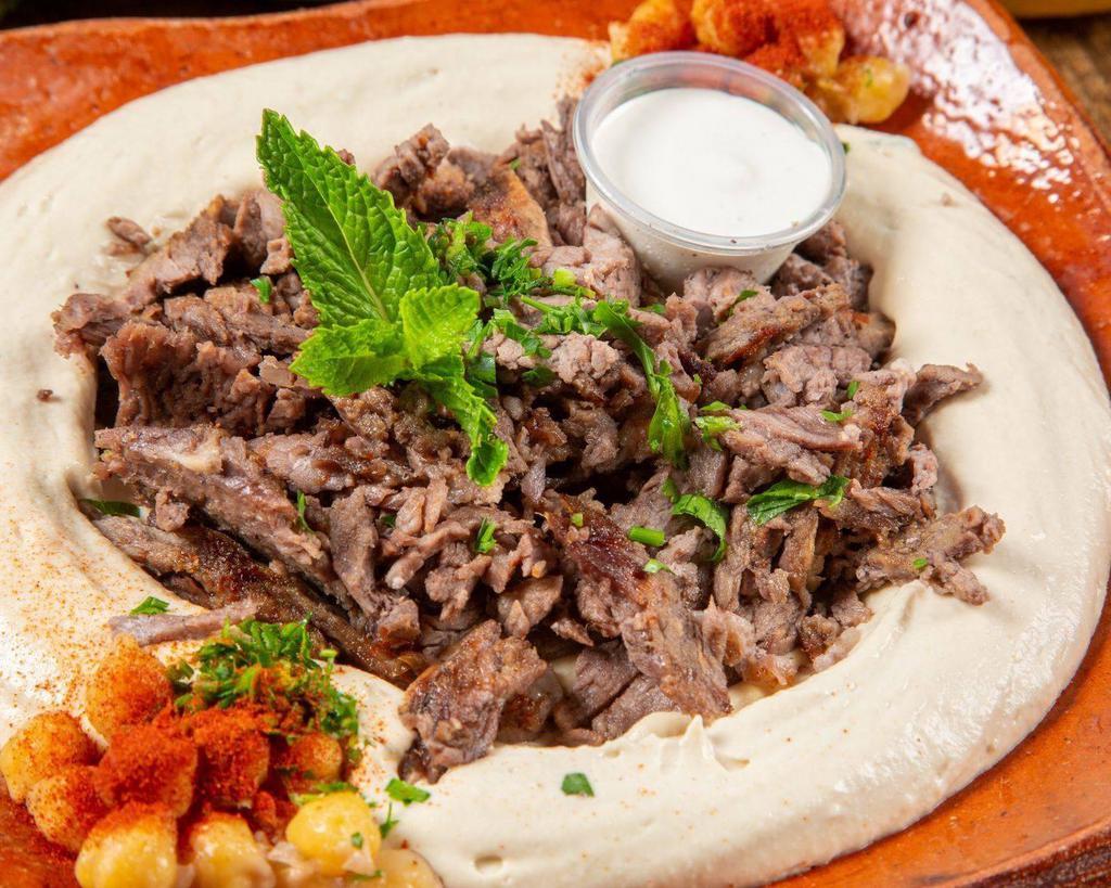 Hummus with Meat حمص مع اللحمة · Hummus dip, topped with lamb shawarma and crispy pine nuts.
