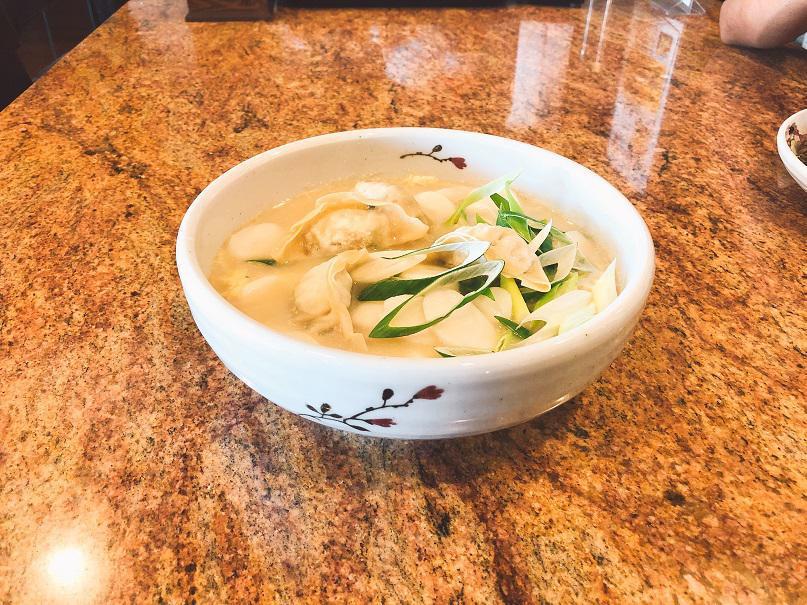 Rice Cake & Dumpling Soup (떡만두국) · Sliced rice cakes, dumplings and shredded beef in clear broth with egg and scallions.