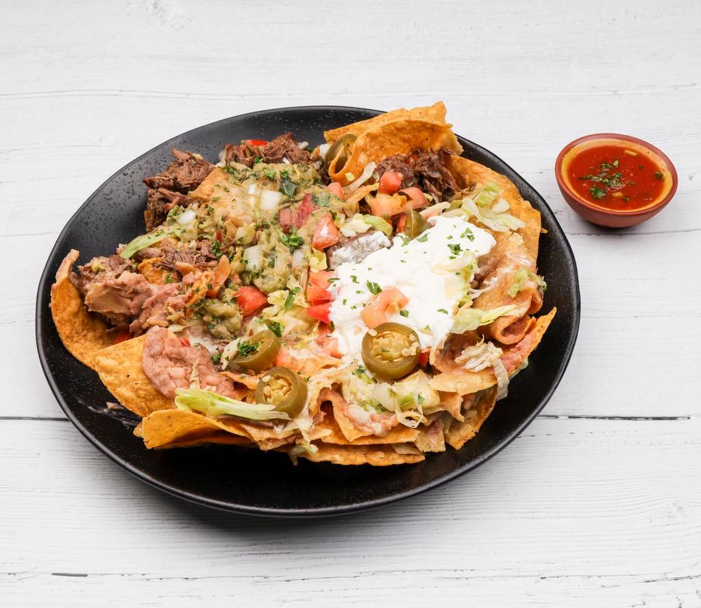 Nachos · Start with a bed of refried beans, tortilla chips topped with choice of shredded or ground beef, chicken or steak meat, cheese, lettuce, tomatoes, jalapeno, guacamole and sour cream.