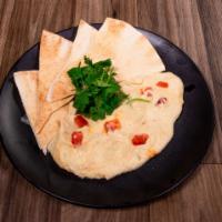 Hummus · A blend of chickpeas, tahini paste, garlic, fresh lemon juice and extra virgin olive oil.
