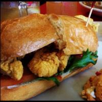 Catfish Po' Boy Sandwich · Cornmeal-battered, fried catfish fillets, mixed greens, lettuce and tomatoes served on a toa...