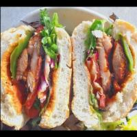 Spicy Chicken Sandwich · Grilled spicy marinated thigh meat, mixed greens, lettuce, onions, tomatoes and roasted pepp...