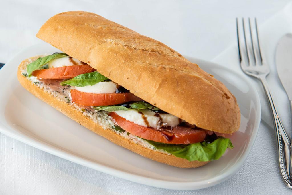 Caprese Sandwich · A freshly baked baguette loaf with a light coat of our labneh spread with generous slices of fresh buffalo mozzarella, heirloom tomatoes and fresh basil topped with a pure olive oil and balsamic glaze drizzle.