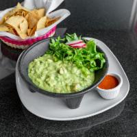 Molcajete de Guacamole · Ripe has avocados smashed with lime juice, onions, cilantro and tomatoes. Served with your c...