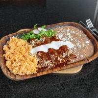 Enchiladas de Mole · Served with rice and beans. Three corn tortillas filled with chicken and topped with our mol...