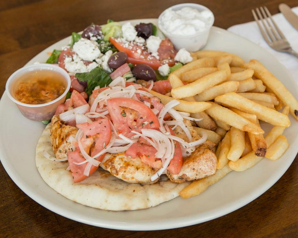 Chicken Souvlaki Platter · Broiled chunks of chicken on a toasted pita with onions and tomatoes, served with greek salad, choice of french fries or rice.
