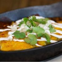 Enchiladas · topped with green & red hatch chile, cheese, onion & crema.  Served with rice & beans