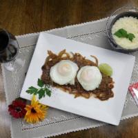 Bife a Caballo · Grilled steak with onions, eggs, and cheese rice.