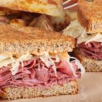 The Rebel Reuben · Hot corned beef, sauerkraut, Thousand Island dressing and melted Swiss cheese on grilled mar...