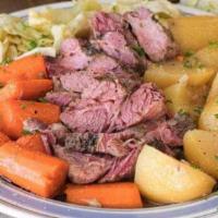 Traditional Corned Beef and Cabbage · Served with boiled red potatoes, buttered carrots, with a parsley cream sauce.