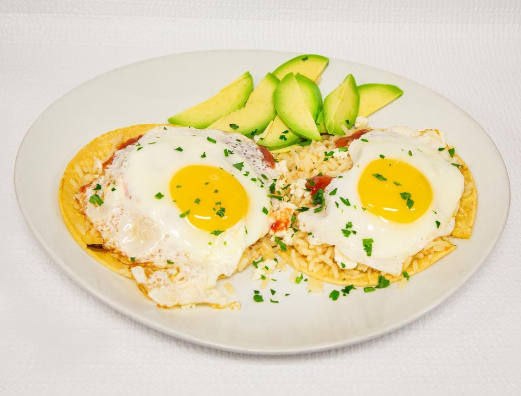 Huevos Rancheros · Rancher’s eggs sunny side up eggs. Served on corn tortillas with beans, rice, guacamole, salsa and crumbled feta cheese with sliced avocado on the side.