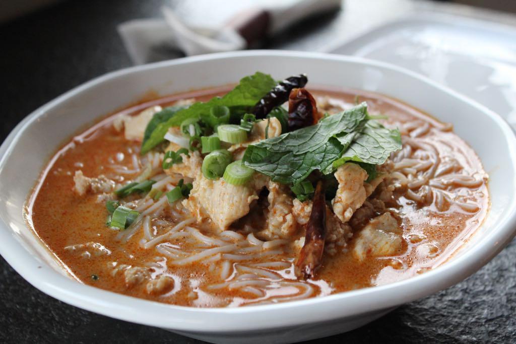 Ka Poon Soup (Gluten-Free) · Mildly spiced. Traditional Lao noodle soup in curry-flavored coconut broth, ground chicken, chicken thighs, shredded cabbages, mint, carrots, bean sprouts, roasted chili, and rice noodles.